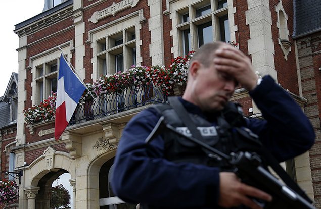A policeman reacts as he secures a position in front of the city hall after two assailants had taken five people hostage in the church at Saint-Etienne-du -Rouvray near Rouen in Normandy.  REUTERS/Pascal Rossignol  